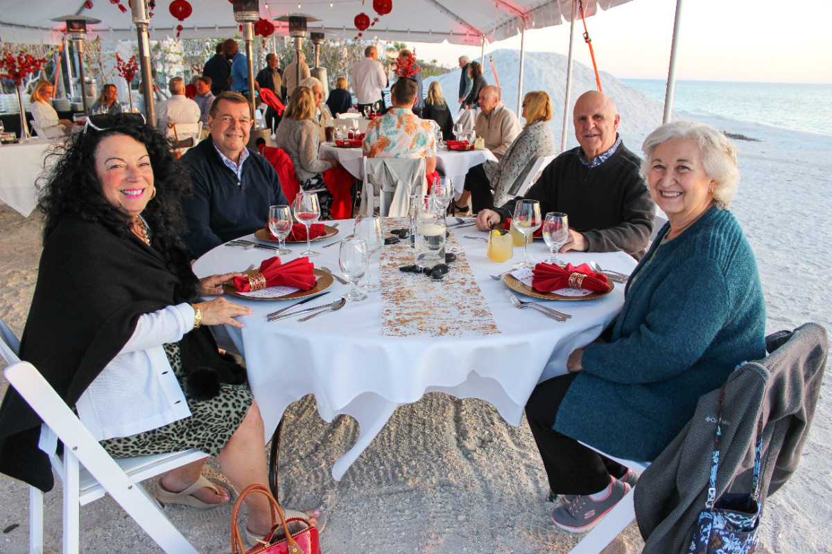 Beach-wedding-reception-dinner-table-guests–-Club-at-Barefoot-Beach